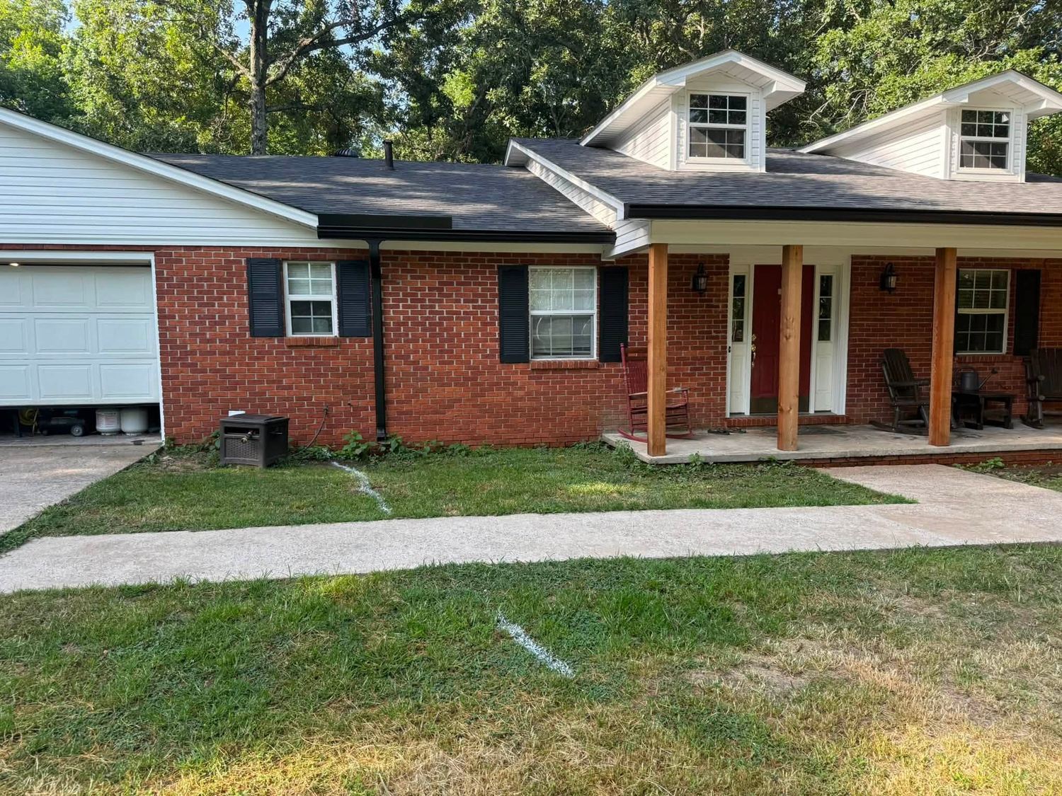 Brick ranch home with a bare front yard and no landscape beds